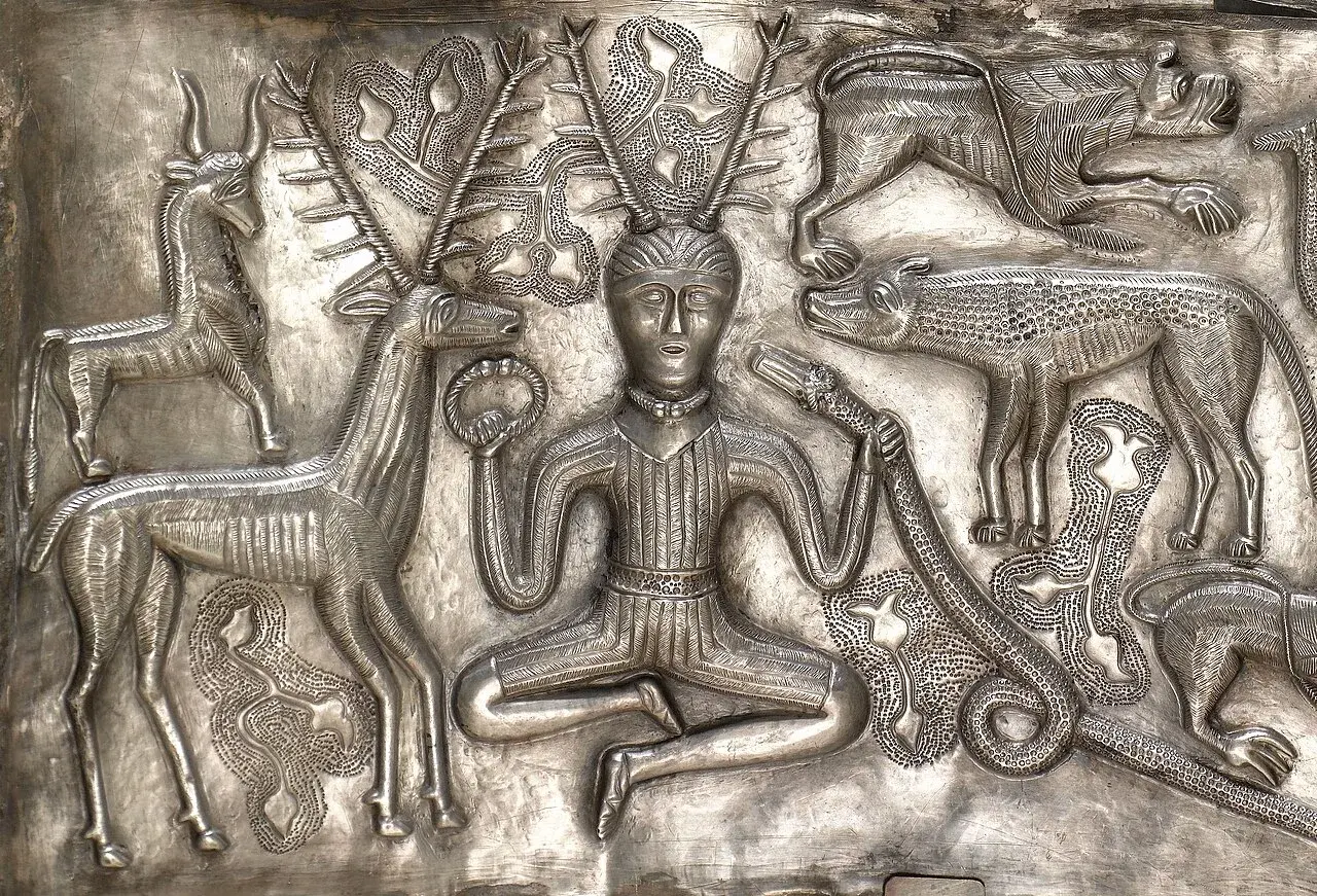 Plaque intérieure du chaudron de Gundestrup montrant Cernunnos assis en tailleur, une ramure de cerf sur la tête, un torque dans une main et un serpent à tête de bélier dans l'autre, entouré d'animaux